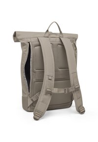 Beige rullattava reppu, jossa pehmustettu selkäosa, säädettävät olka- ja rintaremmit sekä sivulla vetoketjullinen aukko.