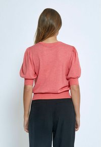 Maglione a maniche corte di colore rosa corallo con maniche a sbuffo e orlo a coste. Tessuto lavorato morbido, con un design semplice e pulito.
