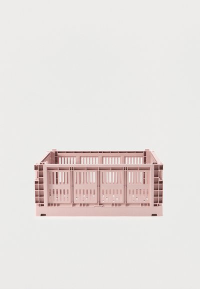 Ορθογώνιο ροζ πλαστικό κουτί με αεριζόμενες σχισμές σε όλες τις πλευρές, σε λευκή επιφάνεια και φόντο.