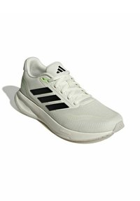 Zapatilla deportiva blanca con parte superior de malla, rayas negras y detalles verdes. Cuenta con una suela de espuma tipo cloud para amortiguación y una banda de rodadura texturizada.