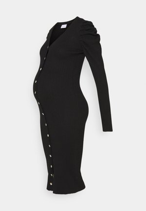 Robe de maternité noire à manches longues avec ouverture boutonnée à l'avant et épaules froncées, cintrée pour mettre en valeur la silhouette du ventre de femme enceinte.