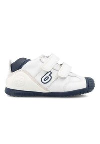 Zapatillas infantiles blancas con acentos en azul marino, dos tiras de Velcro, puntera reforzada y logo en relieve en el lateral. Suela de goma para mayor tracción.