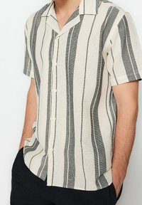 Korte mouwen button-up shirt met een beige en zwart gestreept patroon, gemaakt van textuurstof met een camp collar ontwerp.