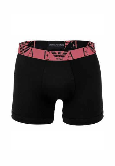 Schwarze Boxershorts mit einem pinkfarbenen elastischen Bund, der ein wiederholtes Logo-Muster zeigt. Weicher Stoff mit glatter Textur und enger Passform.
