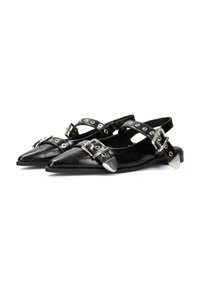 Zapatos slingback de cuero negro con punteras afiladas, detalles de hebilla plateada y herrajes decorativos. Suela plana con un diseño elegante.
