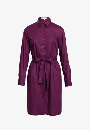 Fioletowa sukienka z długimi rękawami, z kołnierzykiem, przewiązywana w talii, wykonana z miękkiego, gładkiego materiału. Posiada rząd guzików z przodu.