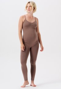Bruine naadloze bodysuit met verstelbare bandjes, getailleerd ontwerp en geribbelde textuur. Rekbaar materiaal, broekspijpen tot de enkels.