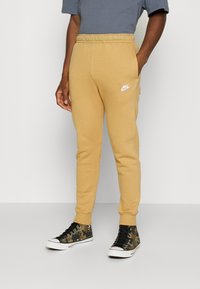 Nike Sportswear CLUB JGGR - Tracksuit bottoms - gold-coloured
