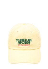Gul bomulds-baseballcap med broderet grønt "STUDIO LAB. RECORDS" og rødt "BROOKLYN, NEW YORK" tekst. Struktureret krone, buet skygge.
