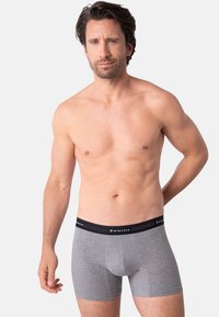 Boxer en coton gris avec une ceinture élastique noire portant le logo "Eminence". Texture lisse et coupe ajustée.