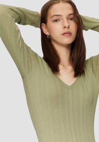 Gestreifter, langärmeliger Oberteil in gedämpftem Grün mit V-Ausschnitt und strukturiertem Muster. Verfügt über eine figurbetonte Silhouette und nahtlose Ärmel.