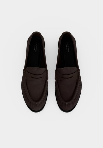 Paire de mocassins en daim brun foncé avec couture style mocassin et une fente décorative sur le dessus, vus de dessus sur fond blanc.