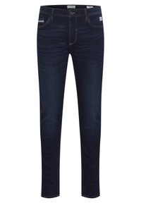 Jeans de denim azul oscuro con un ajuste slim, que presentan un ligero desgaste, costuras claras, diseño de cinco bolsillos y una etiqueta de marca en la cintura.