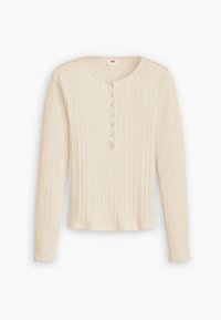 Top de manga larga de canalé en color beige claro con escote redondeado, que presenta múltiples botones pequeños en la parte delantera y un dobladillo corto.