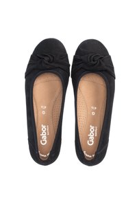 Schwarze Wildleder-Ballettschuhe mit einem geknoteten Design an der Vorderseite, gepolstertem beigen Fußbett und durchbrochenen Details für Atmungsaktivität.