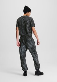 Karl Lagerfeld Jeans CRACKED PRINT SWEAT - Pantaloni de trening - black all over crack print