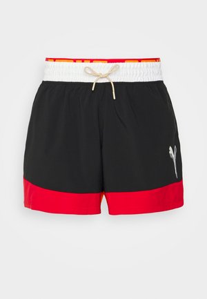 Costume da bagno nero con orlo rosso, vita elastica bianca con coulisse e logo riflettente sul lato sinistro. Tessuto leggero.