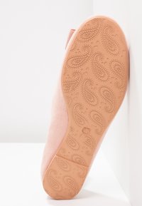 Semelle d'une chaussure plate rose avec un motif cachemire et des motifs de cœur, montrant la taille 37 embossée près du talon.