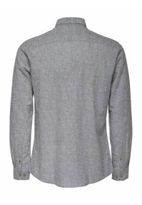 Camisa gris de manga larga con cuello, de tela lisa y texturada, con detalles de botones en los puños, y con un dobladillo curvado.