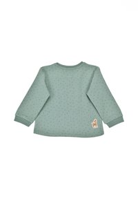 Mintgrünes Longsleeve-Oberteil mit gepunkteter Textur und gerippten Bündchen. Mit einer kleinen Eichel-Applikation auf der unteren rechten Seite.