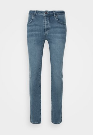 Vaqueros slim-fit azules con bolsillos frontales y cierre de botón, mostrados sobre un fondo blanco.