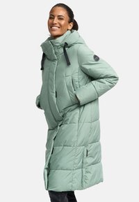 Mint green puffer coat with a high collar, front pockets, and a quilted design. Features black hardware and a logo patch on the sleeve.