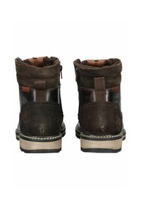 Botas de tobillo de cuero marrón con un suave forro de felpa, detalles de tela, cremalleras laterales y una suela de color claro en contraste.