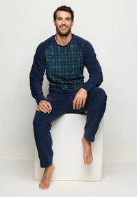Granatowy komplet loungewear z długimi rękawami, z przodem w zielono-niebieską kratę, z miękkiego materiału oraz dopasowanymi spodniami.