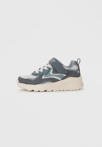 Sportliche Schuhe aus einer Mischung von hellblauen und dunkelblauen synthetischen Materialien, mit gepolstertem Kragen, Klettverschluss, strukturiierter Sohle und Kontrastelementen.