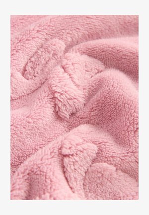 Pătura moale din fleece roz are o suprafață texturată și pufoasă. Materialul are un model ondulat, confortabil, și un aspect pufos.