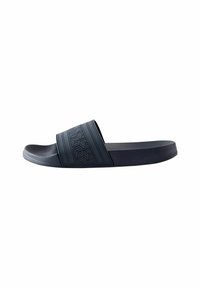 Infradito neri con una fascia testurizzata caratterizzata da motivi geometrici, una soletta liscia e un design minimalista per l'abbigliamento casual.