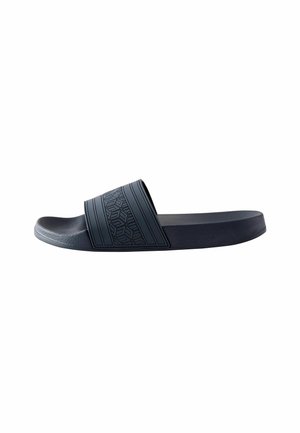 Sandale glissante noire avec une sangle texturée présentant des motifs géométriques, un semelle lisse et un design minimaliste pour une utilisation décontractée.