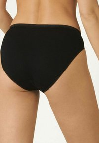 Schwarze Baumwollslips mit glatter Textur, hoher Taille und gewelltem Saum entlang des Bundes. Einfacher und minimalistischer Stil.
