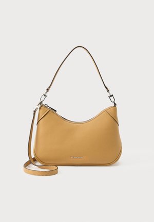 Τσάντα χειρός Michael Kors από μαύρο δέρμα με κοντή λαβή και αφαιρούμενο μακρύ λουρί, μπροστά σε λευκό φόντο.