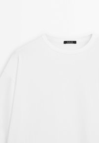 Plain white crewneck long-sleeve shirt with a black label inside the collar reading "Massimo Dutti Made in Portugal."