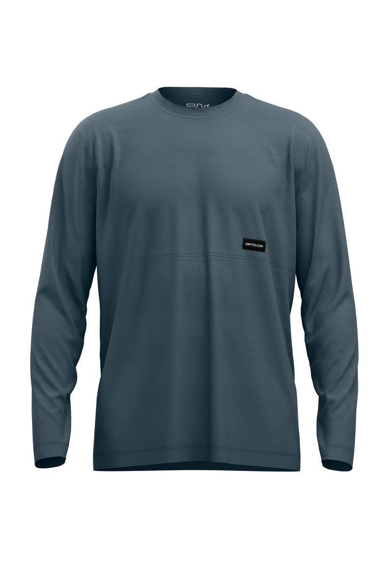 Long-sleeve shirt made of soft fabric in slate blue with a rounded neckline, featuring a black logo patch on the front and tonal stitching.