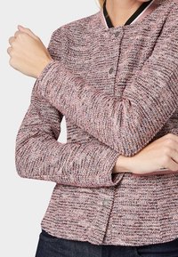 Texturierter rosa und grauer Pullover mit rundem Ausschnitt, langen Ärmeln und vorderen Druckknöpfen. Mit geripptem Saum und dehnbarem Stoff.