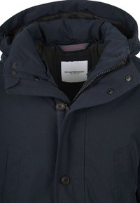 Donkerblauwe jas met capuchon, voorzien van een ritssluiting en drukknopen, gemaakt van een gladde stof met stiksel details en twee voorzakken.