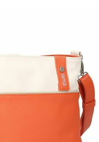 Zwei-farbige Schultertasche in Orange und Creme mit strukturiertem Material, Metallverschluss und verstellbarem orangefarbenem Riemen.