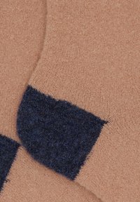 Calzini lavorati a maglia con corpo principale di colore rosa chiaro e polsini testurizzati blu scuro. Il tessuto sembra morbido e caldo, con una finitura liscia e a maglia fine.