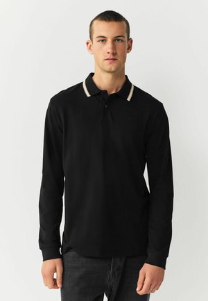 Schwarzes langärmeliges Poloshirt mit einem kontrastierenden gestreiften Kragen. Der Stoff hat eine glatte Textur und zeigt ein dezentes Logo auf der Brust.