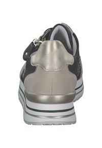 Sneaker nera e beige con tacco metallico dorato, caratterizzata da una finitura liscia e una suola bianca con strisce nere e grigie. Dettaglio con zip sul lato.