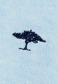 Lichtblauwe gebreide stof met een donkerblauw geborduurd boommotief in het midden. De textuur is zacht en glad.