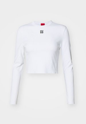 White long-sleeve crop top made of cotton, featuring a round neck and a small black "HUGO" logo on the chest. Smooth texture with fitted design.
