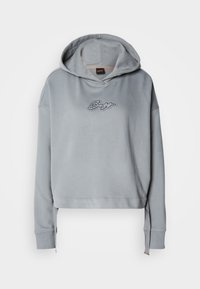 Grå croppet hettegenser med snorhette, med en teksturert logodesign i sølv foran. Mykt stoff, avslappet passform, ribbede mansjetter.