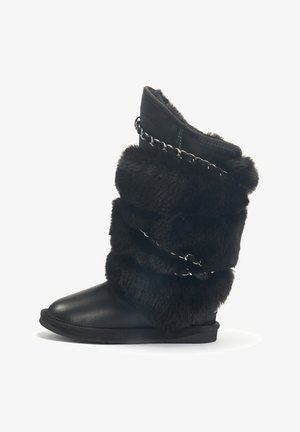 Svarta pälsstövlar med ett lagerdesign, som har en mjuk textur, en slät lädersula och ett kedjeaccent runt toppen.