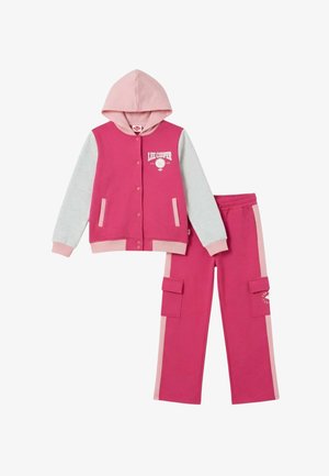 Veste à capuche rose et gris clair avec boutons-pression, associée à un pantalon cargo rose assorti avec poches latérales et bandes rose clair.
