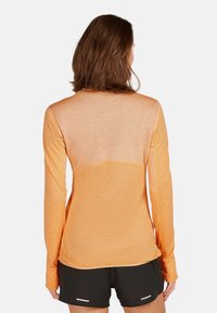 Koszula z długim rękawem w gradientowym pomarańczowym kolorze, z teksturowanej tkaniny i siateczkowym tyłem. Miękki materiał, dopasowany krój i minimalna ilość szwów.