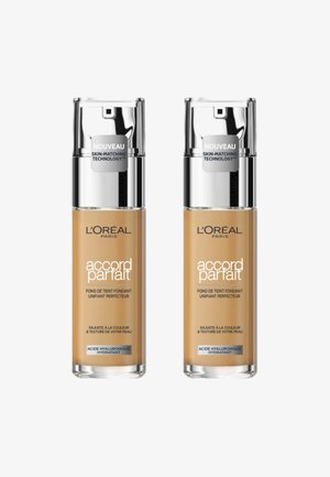 Deux bouteilles de fond de teint Accord Parfait de L'Oréal Paris, en teintes beige, avec des capuchons de pompe argentés et des étiquettes indiquant "technologie d'adaptation à la peau."