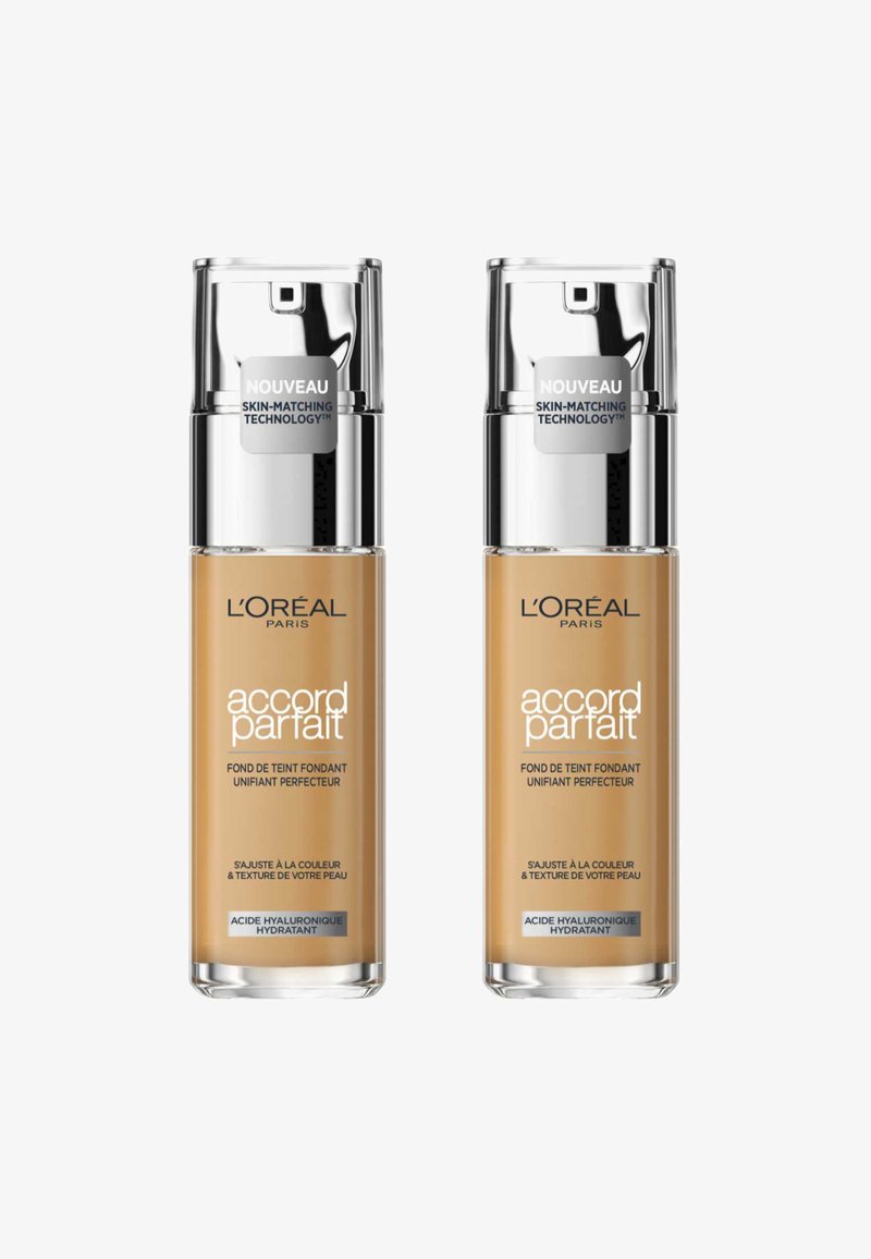 Deux bouteilles de fond de teint Accord Parfait de L'Oréal Paris, en teintes beige, avec des capuchons de pompe argentés et des étiquettes indiquant "technologie d'adaptation à la peau."